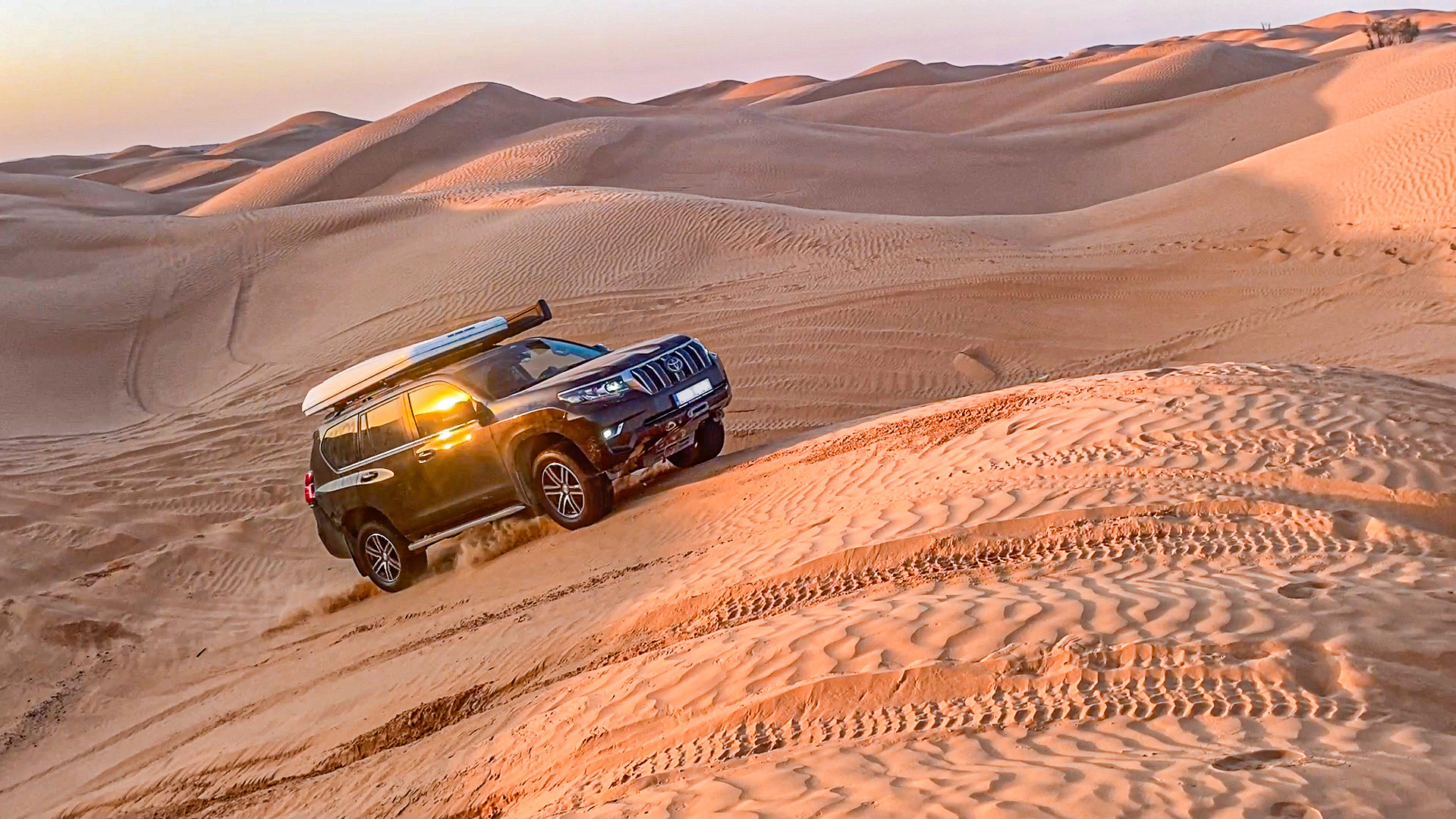 Offroad car driving up the sand dune in Sahara desert