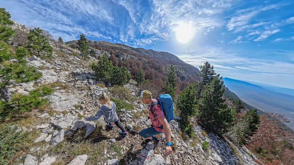 A man and a small girl hiking in the mountains