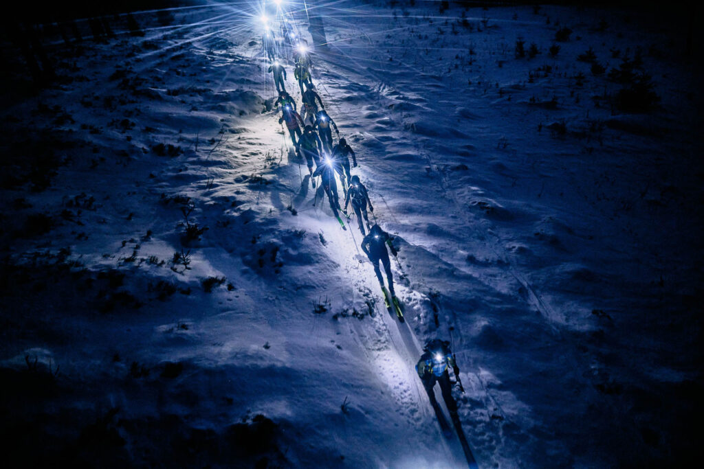 Skimo race at night with headlapms on the snow