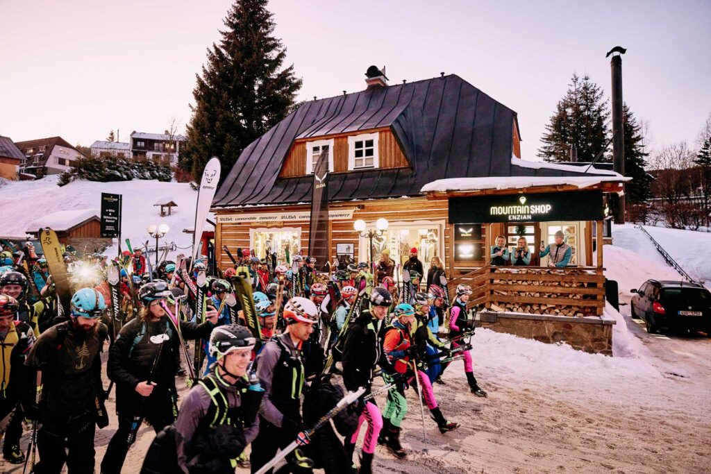 A lots of skimo racers with skis on a backpacks