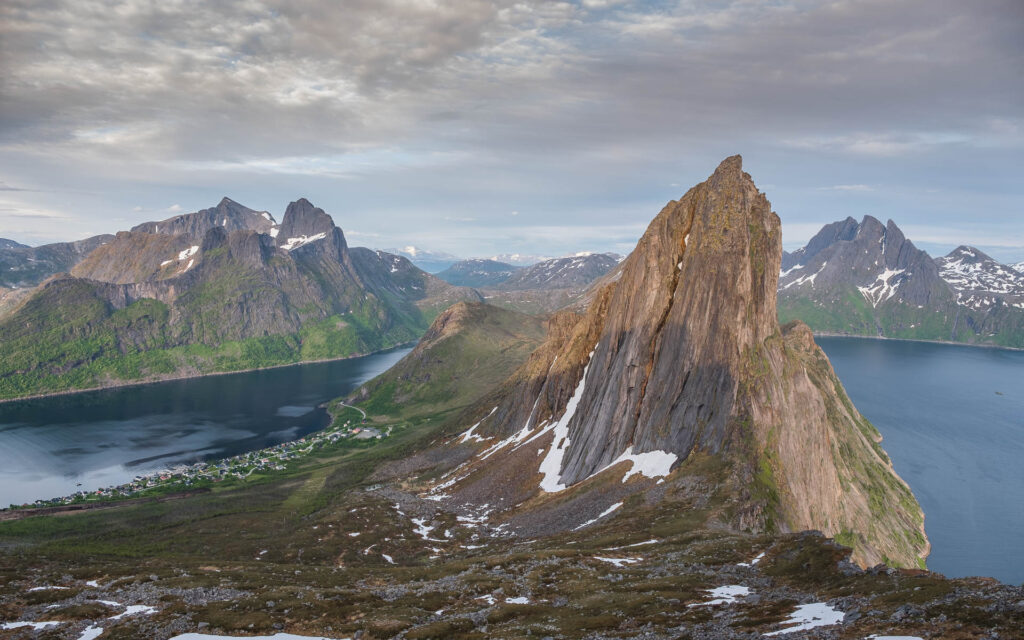 Spike like rock rising up from the atlantic ocean fjord