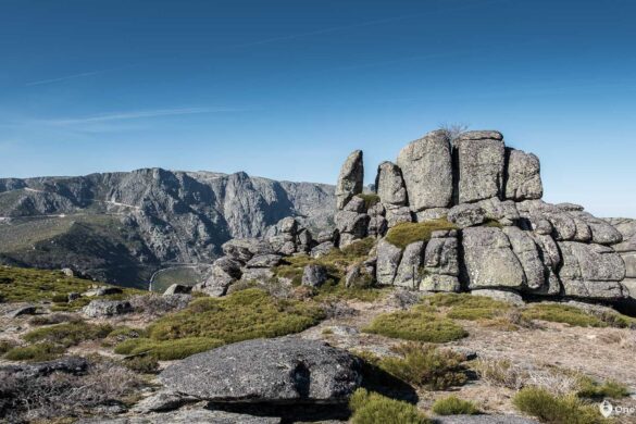 Big rock boulders and steep rocky mountains in background with the perfect blue sky