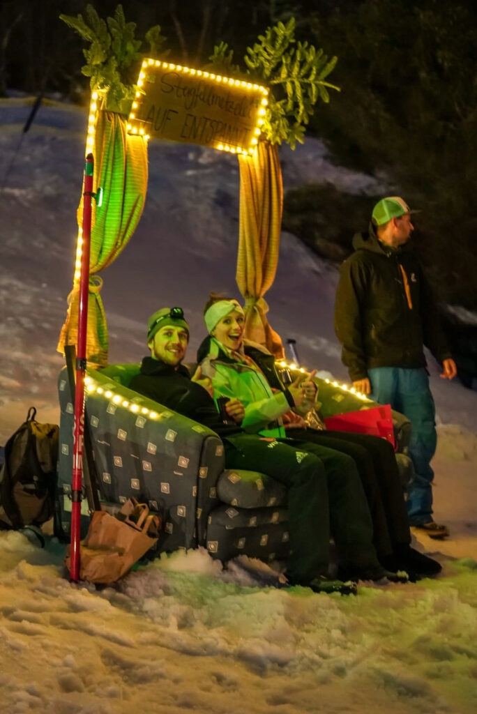 people relaxing on the sofa out on the snow with light gate aroubd